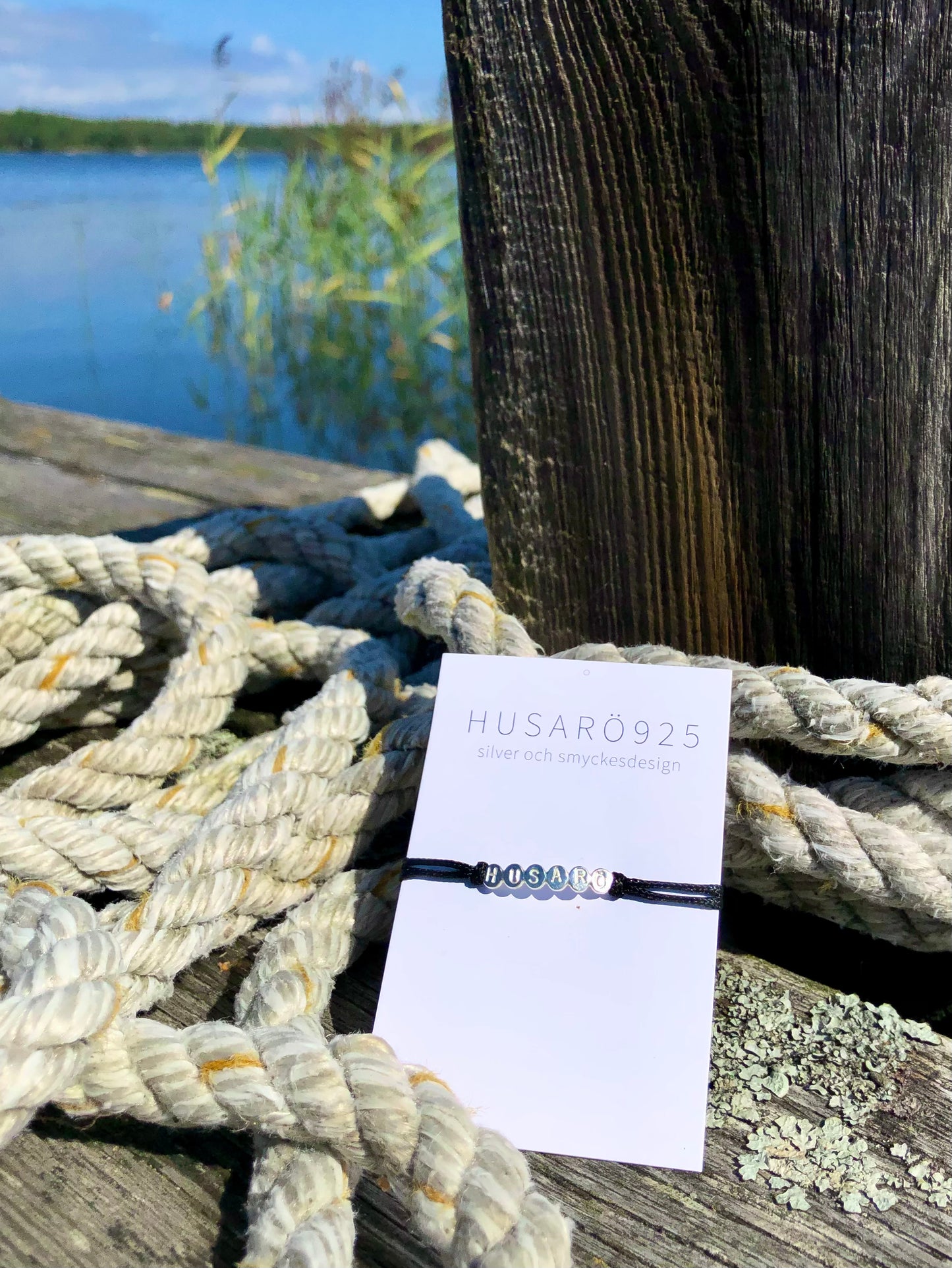 Armband i silver ”HUSARÖ” - busiga bokstäver kultråd